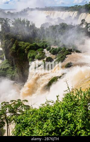 Ein Wasserfall von oben gesehen, ein Teil der Iguazu-Wasserfälle mit umgebender Natur in Argentinien mit Blick auf Bäume und Fluss mit Wassernebel Stockfoto