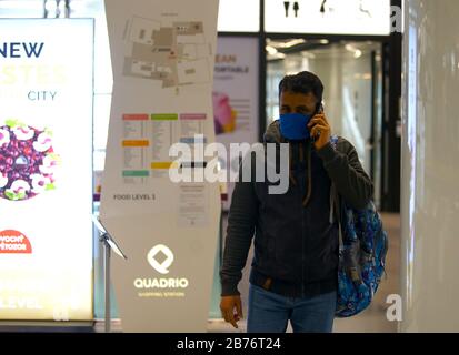 Prag, Tschechien. März 2020. Ein Mann mit Gesichtsmaske ist am 13. März 2020 in einem Einkaufszentrum in Prag, Tschechien, zu sehen. Die tschechische Regierung erklärte am Donnerstag nach einer außerordentlichen Kabinettssitzung zum COVID-19-Ausbruch einen 30-tägigen Ausnahmezustand. Der öffentliche Zugang zu Sportanlagen, Turnhallen, Schwimmbädern, Wellnesseinrichtungen und Saunen, Musik- und Sozialvereinen, Bibliotheken oder Galerien ist am Freitag ab 6 Uhr verboten. Credit: Dana Kesnerova/Xinhua/Alamy Live News Stockfoto