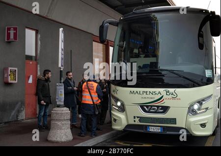 Passagiere, die nach dem Ausbruch des Corona-Virus einen Bus in die Innenstadt nehmen.Aufgrund der schnellen Verbreitung von Coronavirus haben in Italien viele Unternehmen ihre Flüge von und nach Italien gestrichen. Auf dem Flughafen Malpensa wurden nur wenige Passagiere gesehen, die Gesichtsmasken trugen, da die am Flughafen arbeitenden Menschen eine besorgniserregende Situation anprangern, die Bedenken hinsichtlich ihrer Arbeit und Zukunft aufzeigte. Stockfoto