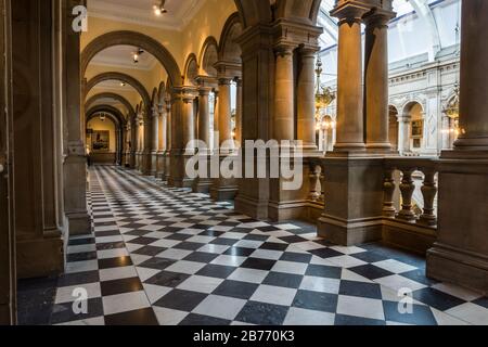 Ein langer kunstvoller Korridor mit Säulen und Statuen in der Kelvingrove Art Gallery and Museum in Glasgow, Schottland. Stockfoto