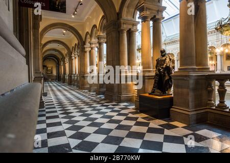 Ein langer kunstvoller Korridor mit Säulen und Statuen in der Kelvingrove Art Gallery and Museum in Glasgow, Schottland. Stockfoto