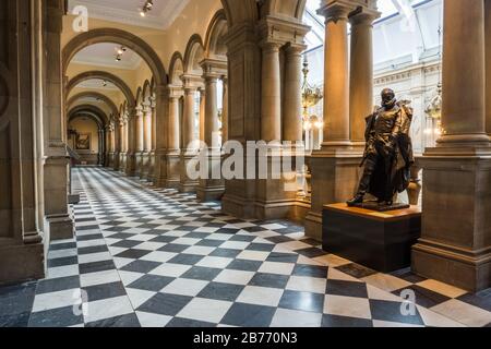Ein langer kunstvoller Korridor mit Säulen und Statuen in der Kelvingrove Art Gallery and Museum in Glasgow, Schottland. Stockfoto