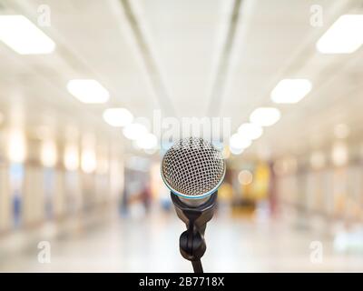 Mikrofon über dem abstrakten, verschwommenen Gang im Seminarraum oder im Konferenzsaal Licht im Hintergrund des Ausstellungszentrums, im Geschäfts- und Bildungszentrum Stockfoto