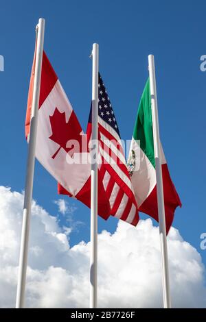 Flaggen von 3 USMCA-Ländern, bestehend aus den Vereinigten Staaten, Mexiko, Kanada auf Flaggenmast gegen Himmel, Konzept eines neuen NAFTA-Abkommens, das als USMCA bekannt ist Stockfoto