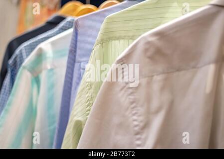 Hemdbündel in Reihe am Kleiderbügel gehängt Stockfoto
