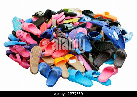 Schuhhaufen, die in verschiedenen Farbkombinationen verkauft werden, ländlicher Landmarkt, Sandalen, lockere Schuhe, alt. Isoliert auf weißem Hintergrund Stockfoto