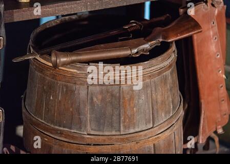 Alte Muzzleloader-Pistole, die auf einem antiken Holzfass steht Stockfoto