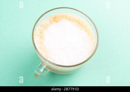 Latte Kaffee in elegantem, transparentem Glas mit Schlagsahne auf dem Minzgrund Stockfoto