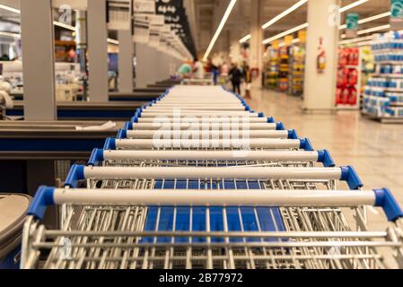 Viele Supermarktkarren handhaben mit geringer Schärfentiefe, wobei ein Teil der Marktansicht verschwommen ist Stockfoto