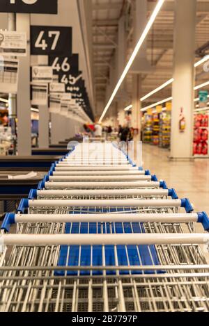 Viele Supermarktkarren handhaben mit geringer Schärfentiefe, wobei ein Teil der Marktansicht verschwommen ist Stockfoto