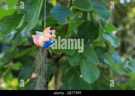 Mit grünem Baumhintergrund hängende Tonpuppe Stockfoto