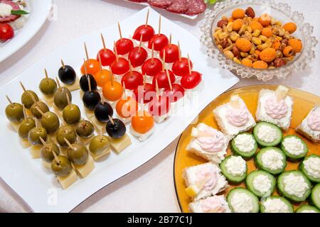 Nahaufnahme kleiner, auf einer Platte angeordneter Canapes über hellem Hintergrund - selektiver Fokus Stockfoto