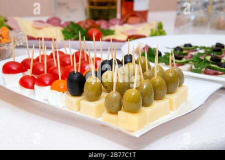 Nahaufnahme kleiner, auf einer Platte angeordneter Canapes über hellem Hintergrund - selektiver Fokus Stockfoto