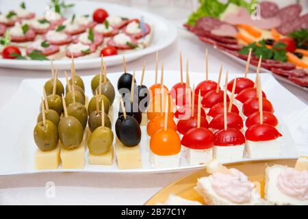 Nahaufnahme kleiner, auf einer Platte angeordneter Canapes über hellem Hintergrund - selektiver Fokus Stockfoto