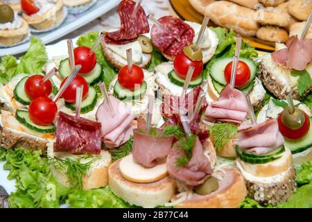 Nahaufnahme kleiner, auf einer Platte angeordneter Canapes über hellem Hintergrund - selektiver Fokus Stockfoto