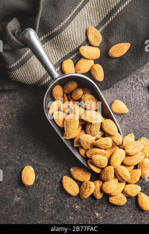 Getrocknete Mandelmuttern in Metallschaufel auf Küchentisch. Draufsicht. Stockfoto