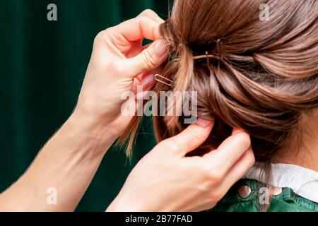 Die Hände machen Frisur für die Rückansicht der Frau aus nächster Nähe. Stockfoto