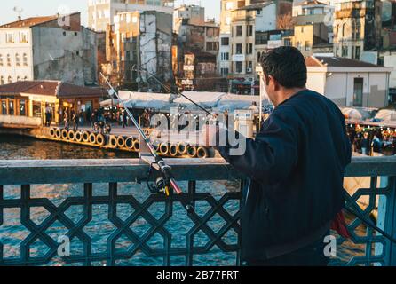 Istanbul, Türkei - 3. Januar 2012: Fischer-Angeln auf der Galata-Brücke mit seinen Angelruten Stockfoto