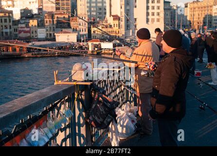 Istanbul, Türkei - 3. Januar 2012: Lokale Fischer angeln auf der Galata-Brücke am Goldenen Horn mit Angelruten am Geländer Stockfoto