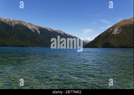 Die klaren Gewässer des Rotoiti-Sees laden zum Schwimmen ein, sie sind von Bergen umgeben. Stockfoto