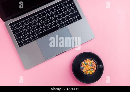 Arbeiten Sie den Computer auf einem rosafarbenen Hintergrund in der Draufsicht. Flaches Lay. Minimales Konzept. Stockfoto