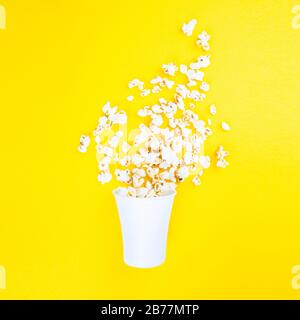 Verstreute Popcorn auf gelbem Hintergrund. Abstraktion und Minimalismus. Stockfoto