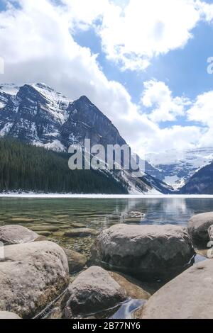 Mount fairview, teilweise gefrorener See, Felsen im Vordergrund. Lake Louise Banff National Park, Alberta Canada. Stockfoto