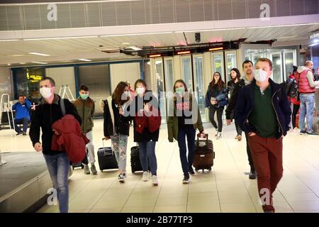 Bukarest, Rumänien. März 2020. Passagiere, die Gesichtsmasken tragen, kommen am 14. März 2020 zum internationalen Flughafen Henri Coanda in Bukarest, Rumänien. Am Freitagnachmittag wurden in Rumänien 80 Fälle von Roman-Coronavirus bestätigt, nachdem am 27. Februar der erste Fall gemeldet wurde, als ein 20-jähriger Rumäne von einem italienischen Besuch infiziert wurde. Kredit: Gabriel Petrescu/Xinhua/Alamy Live News Stockfoto