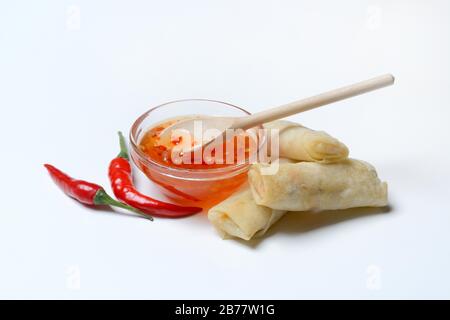 Chilisauce in kleinen Schalen mit Chilipapierern und kleinen Frühlingsrollen, Deutschland Stockfoto