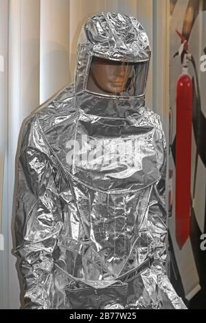 Feuerfester silberner Sicherheitsanzug, der Körper und Kopf bei einem Brand auf Mannequin bedeckt Stockfoto