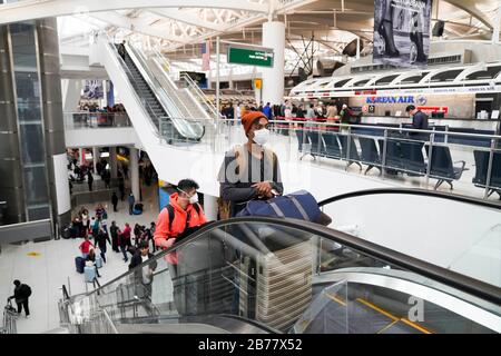 (200314) - New YORK, 14. März 2020 (Xinhua) - Passagiere nehmen eine Rolltreppe am John F. Kennedy International Airport in New York, USA, 13. März 2020. Die Vereinigten Staaten setzten die Beschränkungen um, die alle Reisen aus europäischen Ländern mit Ausnahme Großbritanniens für 30 Tage aussetzen, in einer Maßnahme, die mit einer weiteren Verbreitung des COVID-19 Freitag um Mitternacht konfrontiert war. US-Präsident Donald Trump erklärte am Freitag einen nationalen Notfall, um 50 Milliarden US-Dollar an Bundeshilfen zu öffnen, um die Verbreitung von COVID-19 im ganzen Land zu bekämpfen. (Xinhua/Wang Ying) Stockfoto