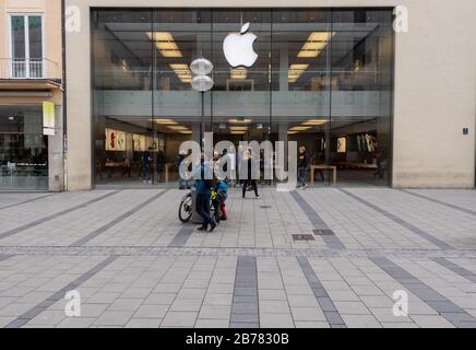 München, Deutschland. März 2020. Einige Passanten stehen vor der Eingangstür eines Applestore in der Innenstadt. Apple schließt alle Geschäfte außerhalb Chinas für zwei Wochen. Kredit: Peter Kneffel / dpa / Alamy Live News