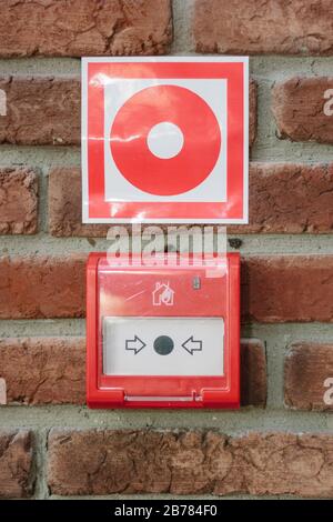 Alarmschalter in der Notfallanlage über einer Wand Stockfoto