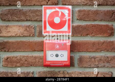 Alarmschalter in der Notfallanlage über einer Wand Stockfoto