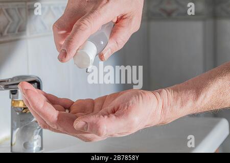 Reinigen oder waschen Sie die Hände mit einer kleinen Flasche Alkohol Gel Desinfektionsmittel. Virusbakterien, schmutzige Hautpflege. Schutz gegen Corona-Virusinfektion Stockfoto