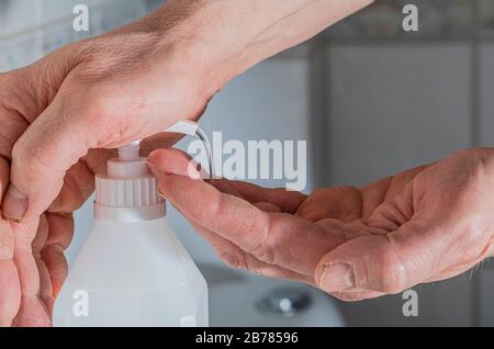 Mit Alkohol Gel Desinfektionsmittel, um die Hände zu reinigen oder zu waschen. Virusbakterien, schmutzige Hautpflege. Schutz vor Corona-Virusinfektion, Kovid19. Mann h Stockfoto