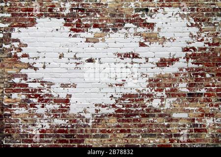 Eine Außenwand aus Backstein im Retro-Stil, weiß gestrichen und geknackt Stockfoto