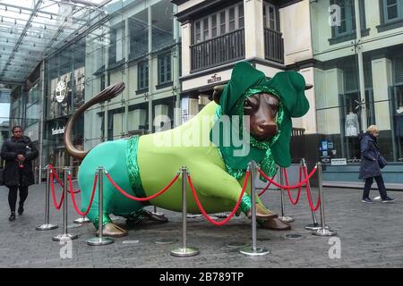 Birmingham, West Midlands, Großbritannien. März 2020. Der Bullring's Bull war für den St. Patrick's Day verkleidet, der morgen, Sonntag, den 15., stattfinden sollte und jetzt in Birmingham abgesagt wurde. Ein fast leeres Stadtzentrum von Birmingham, da die Mehrheit der Käufer zu Hause blieb, um online einzukaufen, um zu verhindern, dass sie mit COVID-19 infiziert wurden. Normalerweise packen Tausende von Menschen die Straßen von Birmingham an einem Wochenende, aber viele Geschäfte waren so leer wie die Straßen selbst, und das Bullring Shopping Centre war ungewöhnlich ruhig. Quelle: Stop Press Media/Alamy Live News Stockfoto