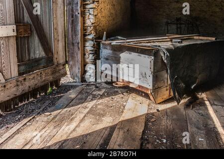 Raue Inneneinrichtung einer alten Holzscheune im Osten von Pennsylvania mit antiken Anbaugeräten Stockfoto