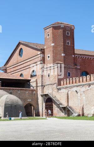 Historischer Turm in der mittelalterlichen Werft Arsenal oder Arsenale und Waffenschmiede, Venedig, Venetien, Italien mit Betonmunition auf der linken Seite Stockfoto