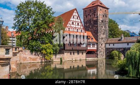 Nürnberg 2019. Weinstadel House, Hangman's Tower und Henkersteg oder Hangman's Bridge an der Pegnitz. Wir sind an einem heißen und trüben Sommertag. Stockfoto