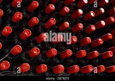 Nahaufnahme mehrerer Flaschen Wein hintereinander in Kellern von Weinkellereien oder Restaurants. Nützlich als Hintergrund. Stockfoto