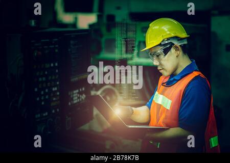 Arbeiter bedienen CNC-Maschine mit G-Code-Monitor, hochqualifizierte Arbeitsbranche mit Sicherheitskleidung dunkelgrüner Farbton für High-Tech-Skill-Con Stockfoto