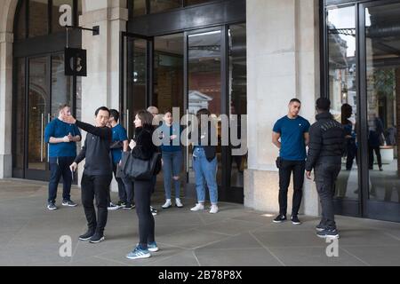 Mitarbeiter stehen außerhalb des Apple Store in Covent Garden, London, da sie Kunden sagen, dass der Shop geschlossen ist. Apple schließt alle Geschäfte außerhalb Von Großchina bis zum 27. März als Reaktion auf die Coronavirus-Pandemie. Stockfoto