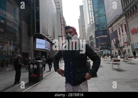 Ein Besucher des Theaterviertels trägt eine Gasmaske, die als Vorsichtsmaßnahme gegen die Verbreitung von Coronavirus am Times Square gilt.Inmitten der Bedenken von COVID19 (Coronavirus) und eines Verbots von Gruppen von 500 Menschen, eine Richtlinie des New Yorker Staates Andrew Cuomo, Alle Broadway-Auftritte sind bis zum 12. April 2020 geschlossen. Die Präsidentin Charlotte St. Martin von der Broadway League gab an, dass der Broadway sich verpflichtet habe, die Bereicherung zu bereichern und zu fördern und all das zu inspirieren, während er seine Besucher unterhält. Darüber hinaus ist die Liga verpflichtet, alle in der Branche arbeiten zu schützen. Stockfoto