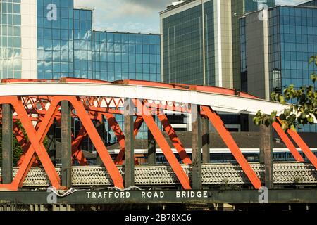 Die orangefarbene Trafford Road Bridge über dem Manchester Ship Canal mit World Trade Center am Exchange Quay, Salford Quays, Manchester, England, UK Stockfoto