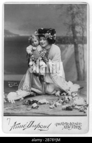 Geraldine Farrar, 1882-1967, volle Länge, kniend, nach links gerichtet; in der Rolle des "madamen Schmetterlings", das orientalische Kostüm trägt und ein kleines Kind hält Stockfoto