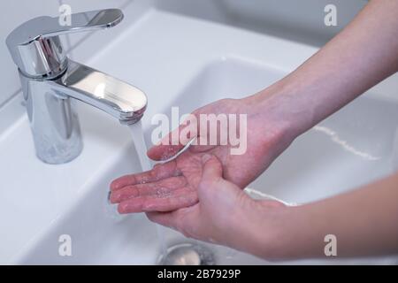 Frau waschen ihre Hände gründlich mit Seife im Waschbecken. Lizenzfreies Foto. Stockfoto