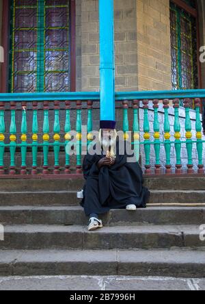 Priester sitzen auf der Treppe der Entoto orthodoxen Maryam-Kirche, Addis Abeba Region, Addis Abeba, Äthiopien Stockfoto