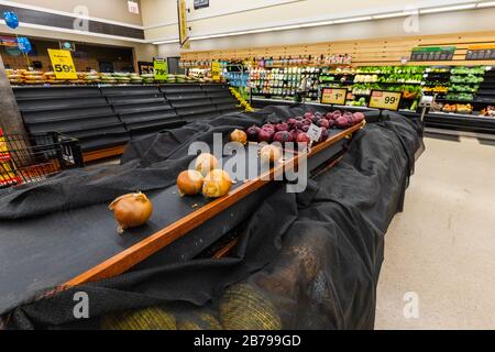 Leere Regale mit Zwiebeln und anderen Produkten in einem Supermarkt Lebensmittelgeschäft als Coronavirus verursacht Angst und Panik Stockfoto